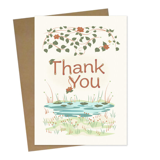 Mockup for greeting card digital design showing hanging vines above a lily pond which has one happy frog below the phrase "Thank You"